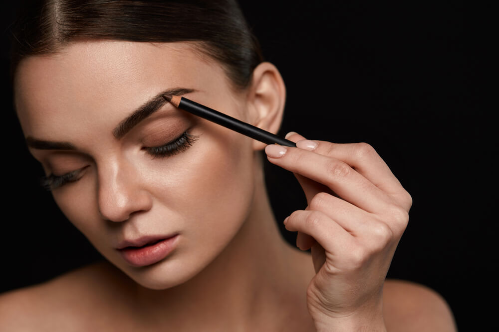 Woman creating black eyebrows