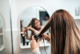 Woman straightening hair