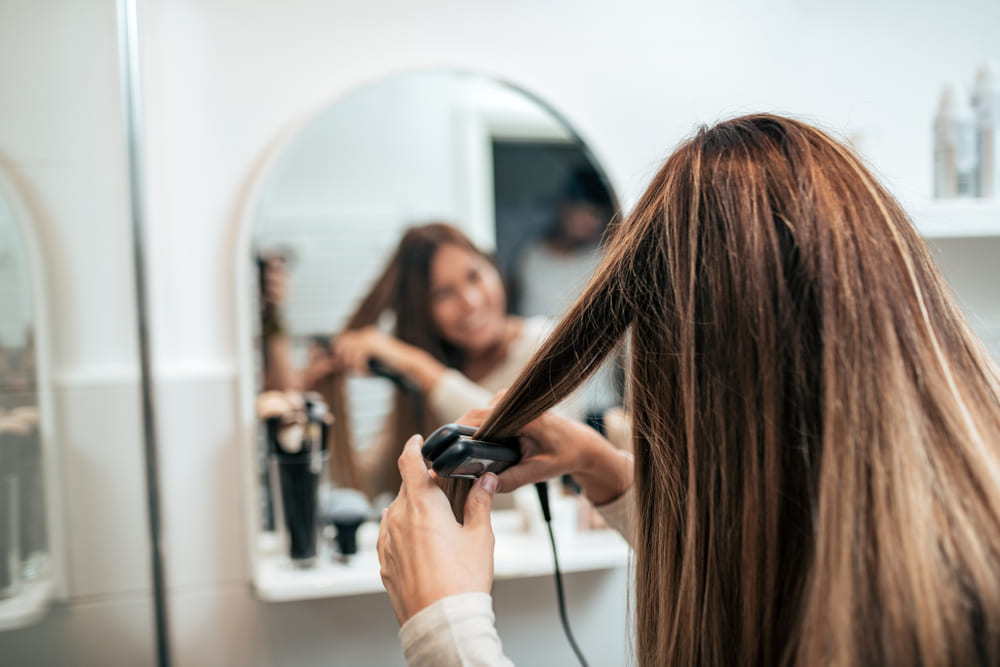 Woman straightening hair
