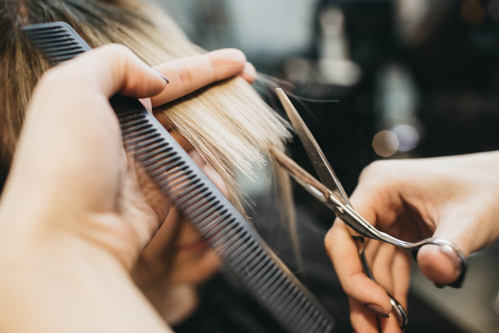 Woman having hair trimmed