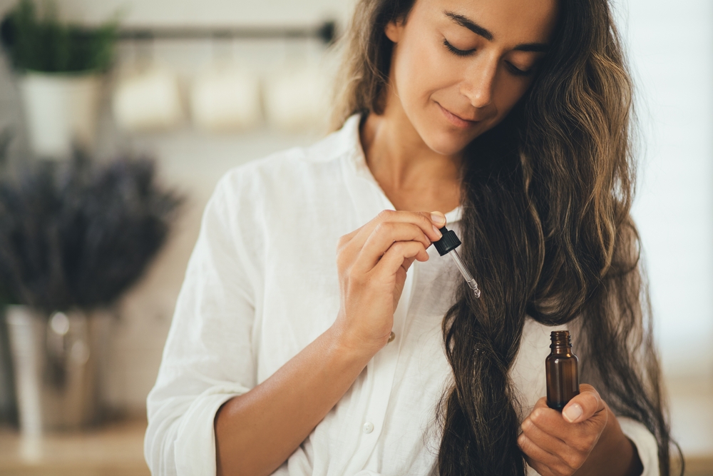 Woman applying hair serum