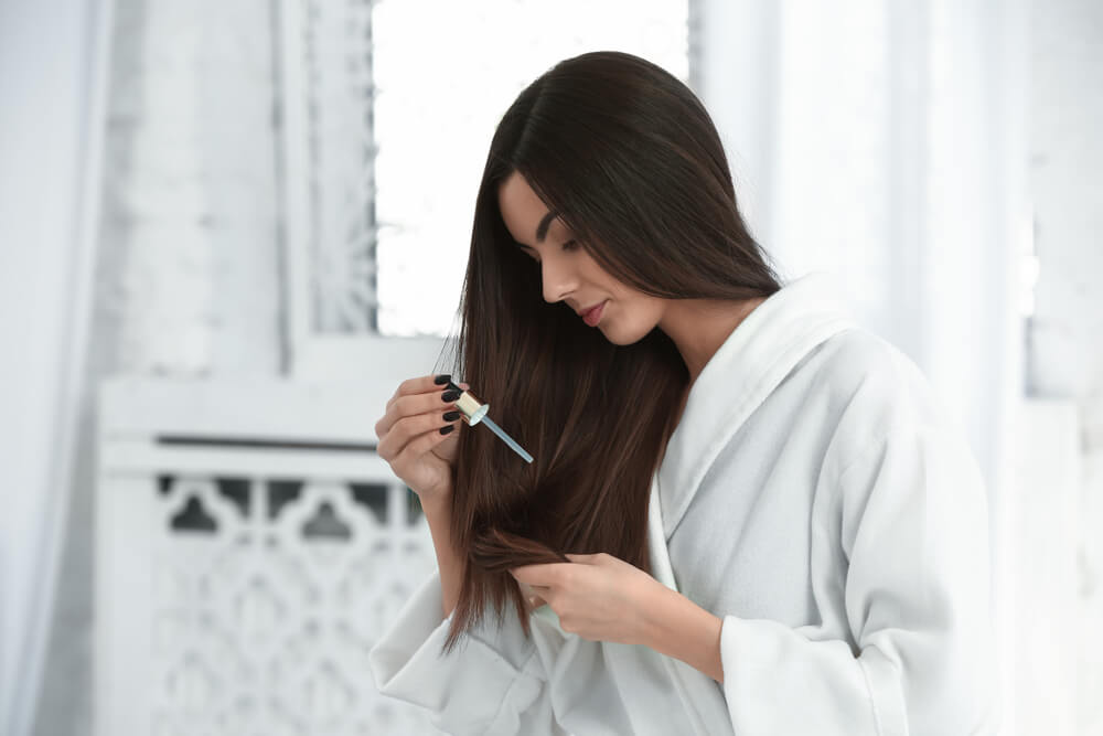 Woman applying hair serum