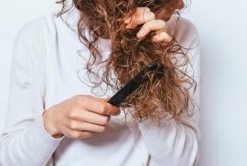 Woman combing tangled hair