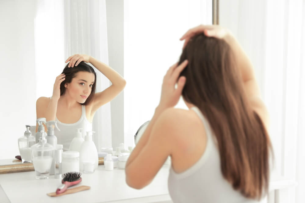 Woman looking at her hair in mirror