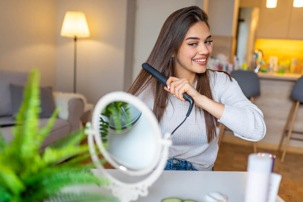 Woman straightening hair - curly hair product