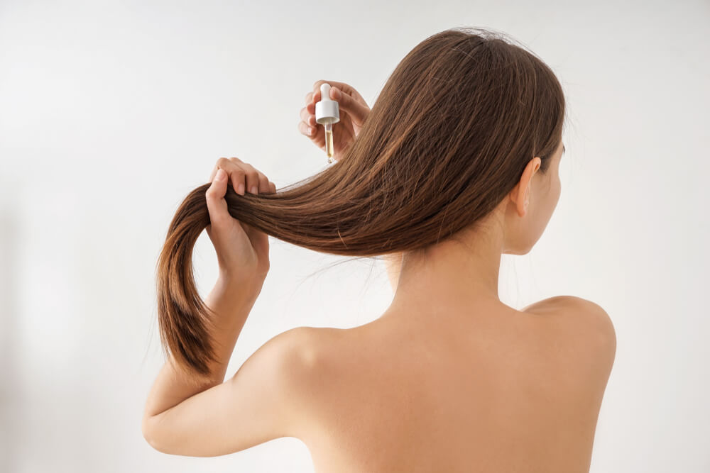 Woman applying the new evolution hair serum