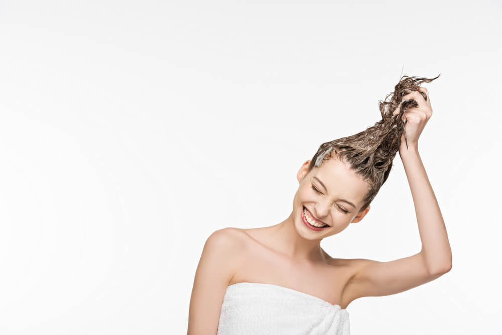 woman smiling holding hair