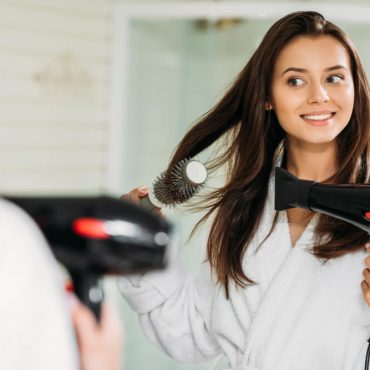 woman blow drying her hair