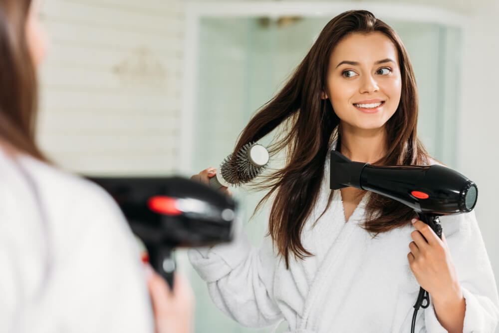 woman blow drying her hair